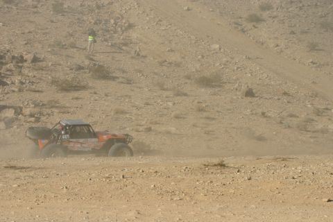 1992 Jeep Wrangler - This off-road buggy races through a dusty desert terrain, with a spectator observing from a nearby hill.
