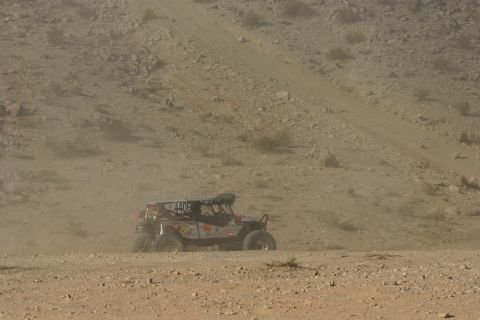 1992 Jeep Wrangler - Off-road buggy competes in a desert race, kicking up dust on the track.