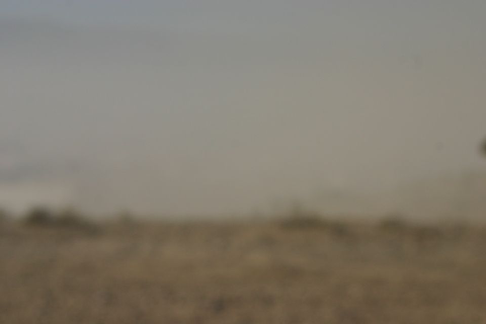 off-road vehicle kicking up dust on a dirt track