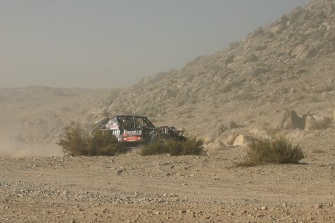 1992 Jeep Wrangler - A custom-built off-road buggy navigates a rocky, arid terrain during a race.
