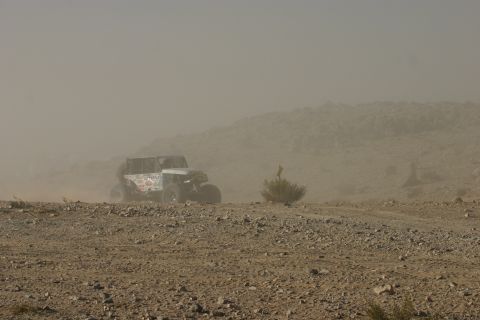 1992 Jeep Wrangler - Off-road vehicle kicks up dust on a desolate, rocky landscape.