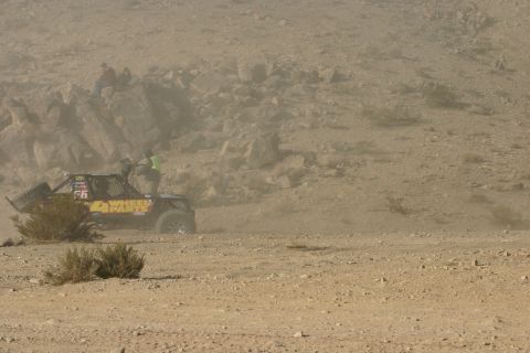 1992 Jeep Wrangler - A buggy competes in a desert race, with spectators watching from a rocky hillside.