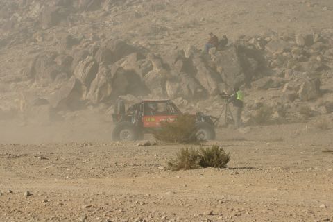 1992 Jeep Wrangler - A buggy races through a dusty desert landscape, observed by onlookers and a videographer.