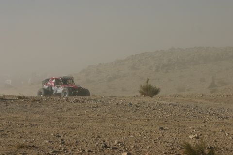 1992 Jeep Wrangler - A red off-road buggy kicks up dust while racing through a desert landscape.