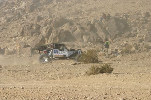 1992 Jeep Wrangler - Buggy competes in a desert race, with spectators and a cameraman observing the action.