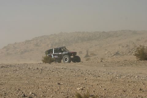 1992 Jeep Wrangler - A modified off-road buggy navigates a dusty desert landscape during an event.