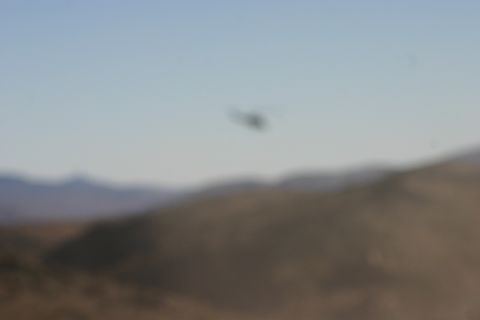 1992 Jeep Wrangler - A distant helicopter is visible against a clear sky, with rolling hills in the foreground.