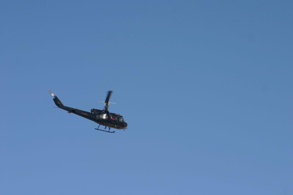 Black helicopter in flight against a clear blue sky