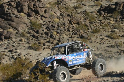1992 Jeep Wrangler - A custom-built off-road buggy navigates a dusty, rocky terrain during a competition.