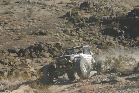 1992 Jeep Wrangler - A heavily modified off-road vehicle navigates a challenging desert terrain.