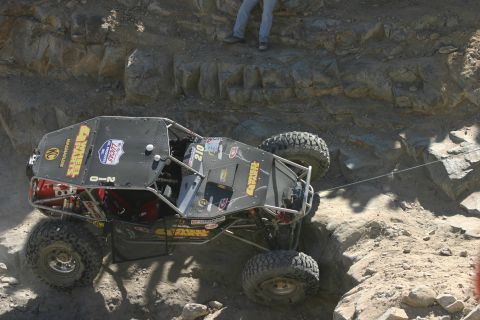 1992 Jeep Wrangler - A heavily modified off-road vehicle navigates a challenging rocky terrain during an event.