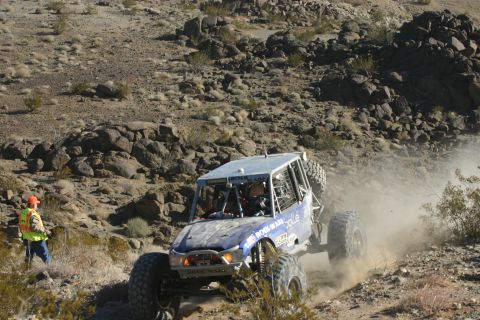 1992 Jeep Wrangler - A custom-built off-road buggy navigates a dusty, rocky terrain during an event.