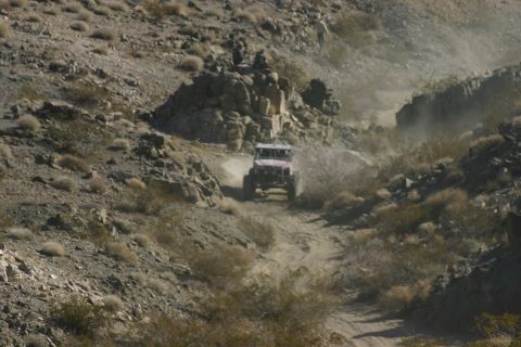 1992 Jeep Wrangler - A vehicle navigates a challenging off-road course in a dry, mountainous environment.