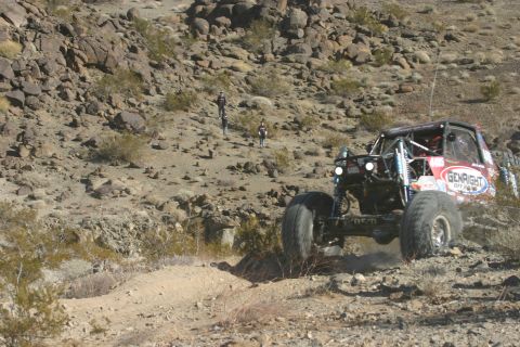 1992 Jeep Wrangler - A custom off-road buggy navigates a steep, rocky incline during an event.
