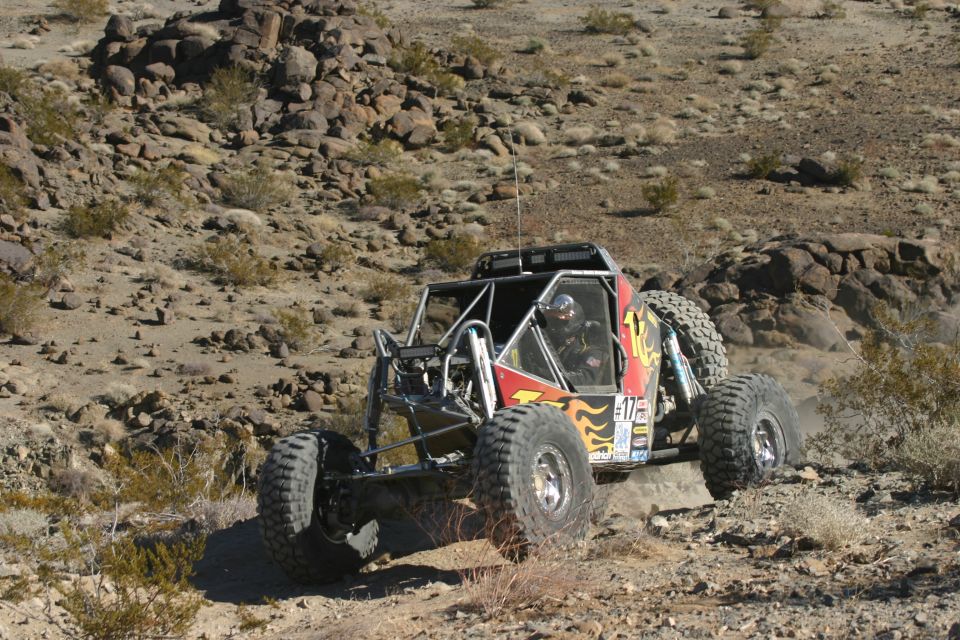 Off-road buggy with flames and number 17 on side, driving on desert terrain