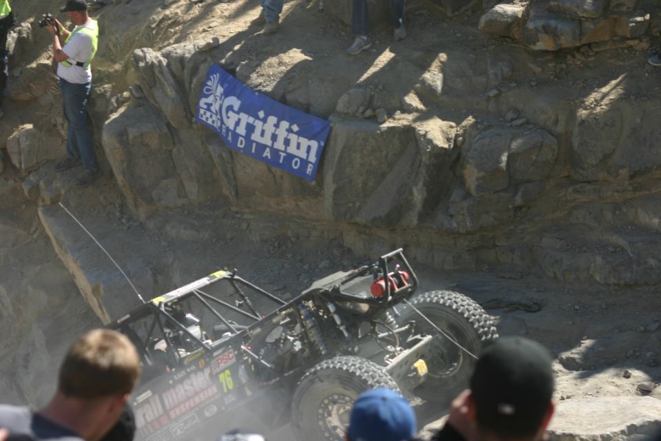 Off-road buggy with 'Trail Master' and '76' visible, climbing rocks