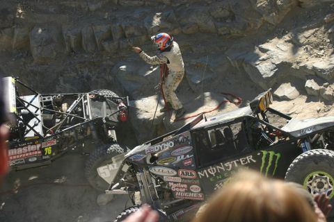 1992 Jeep Wrangler - Two off-road vehicles navigate a challenging rocky course, with a driver assisting from atop one of the vehicles.