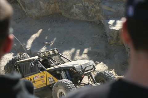 1992 Jeep Wrangler - An off-road vehicle navigates a challenging rocky course, its large tires gripping the terrain.