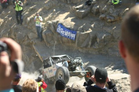 1992 Jeep Wrangler - Spectators watch an off-road buggy tackle a challenging rocky terrain during an event.