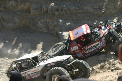 1992 Jeep Wrangler - Two custom off-road vehicles navigate a challenging rocky terrain during a competition.