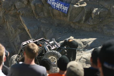 1992 Jeep Wrangler - A custom-built off-road buggy is being worked on during a competition with spectators observing the action.