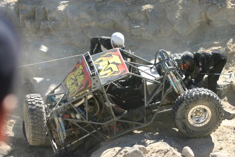 1992 Jeep Wrangler - Off-road buggy with 'Trail Gear' graphics is being worked on by people in helmets.