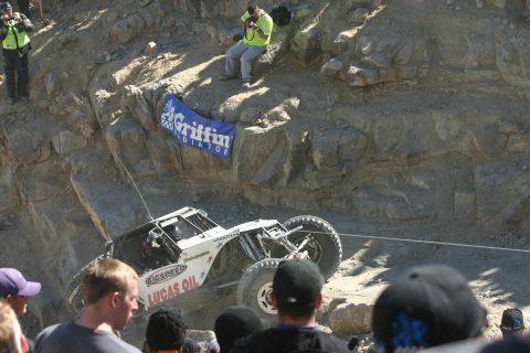 1992 Jeep Wrangler - A custom-built off-road vehicle navigates a challenging rocky terrain, with spectators observing the event.