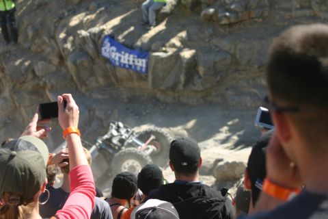 1992 Jeep Wrangler - Spectators watch an off-road vehicle navigate a difficult rocky course, with a 'Griffin' banner visible in the background.