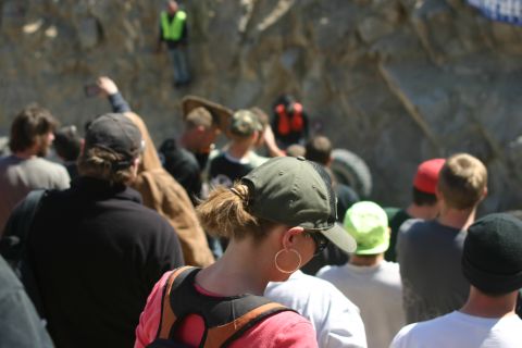 1992 Jeep Wrangler - Spectators observe an off-road event, with a rocky cliff face and a spare tire visible in the background.