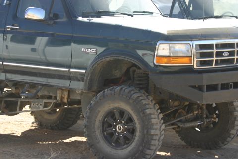 1992 Jeep Wrangler - This modified Ford Bronco features a custom bumper and aggressive off-road tires, suggesting it's built for terrain.