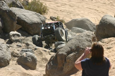 1992 Jeep Wrangler - A custom off-road vehicle tackles a challenging rocky obstacle in a desert environment.