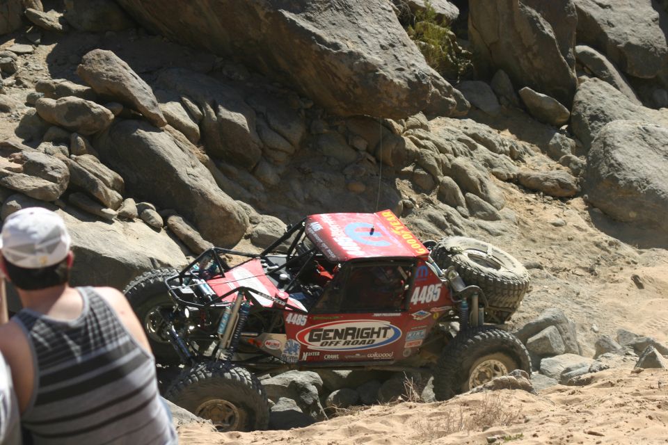 Red off-road buggy with number 4485 on the side, navigating rocky terrain