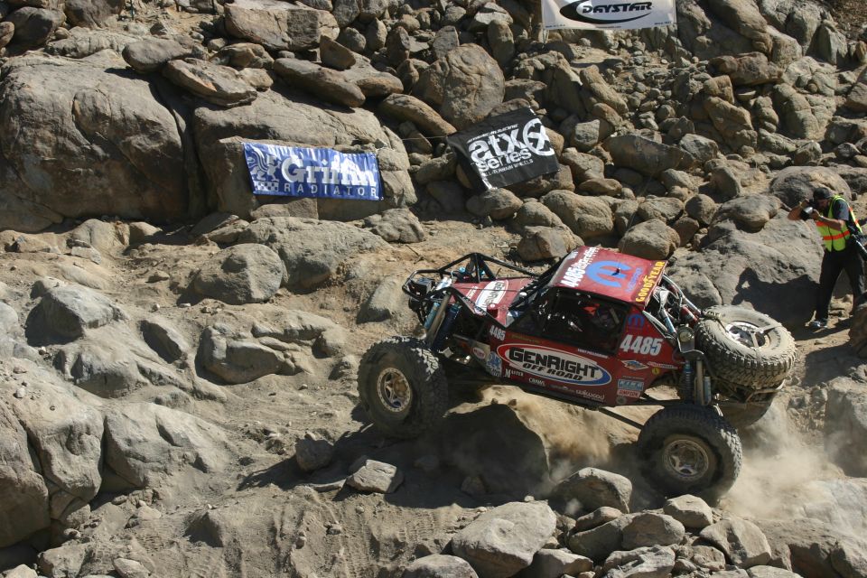Red off-road buggy with number 4485 climbing rocks