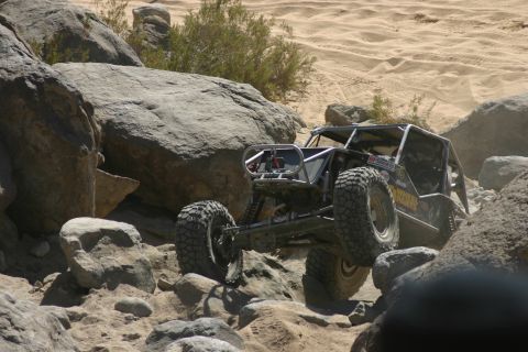 1992 Jeep Wrangler - This custom off-road buggy navigates a rocky desert terrain, kicking up dust as it goes.