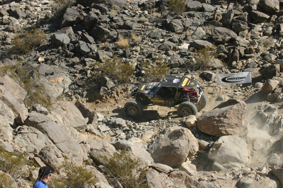 Custom off-road buggy navigating a steep, rocky trail. A banner reads 'DRYSTAR'
