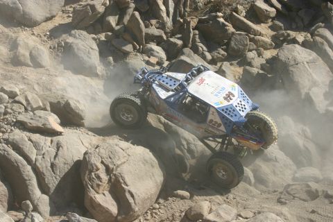 1992 Jeep Wrangler - A custom-built off-road buggy navigates a rocky, dusty terrain during a race.
