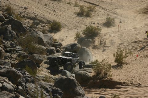 1992 Jeep Wrangler - A custom-built buggy navigates a challenging off-road course with steep inclines and large boulders.