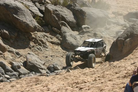 1992 Jeep Wrangler - An off-road buggy navigates a challenging, dusty terrain during a competition.