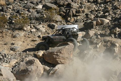 1992 Jeep Wrangler - Custom off-road buggy with roll cage navigates rocky terrain during an event.
