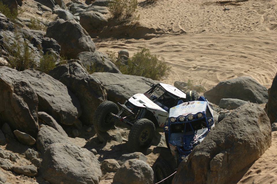 Two off-road buggies navigating a rocky desert terrain
