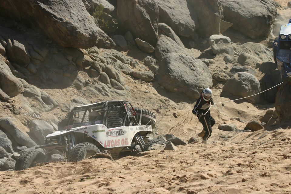 Off-road buggy with Lucas Oil sponsorship, 3q-front view, in a rocky desert landscape