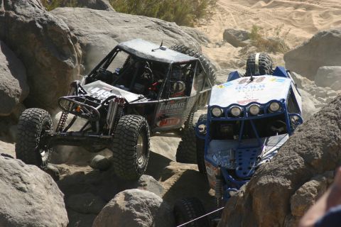 1992 Jeep Wrangler - Two custom off-road vehicles tackle a challenging rocky course during an event.