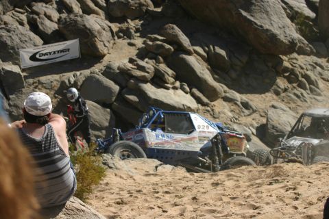 1992 Jeep Wrangler - Off-road race vehicles tackle a challenging desert course with rocky inclines and sandy terrain.