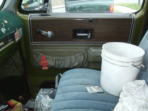 1979 Ford Bronco - The interior of a truck shows a door panel with wood trim and a bucket on the seat.