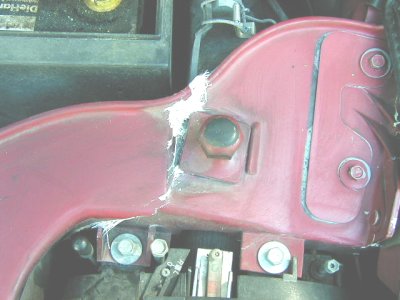 1997 Ford Taurus - Close-up view of engine bay components, including a red painted metal structure and a battery.