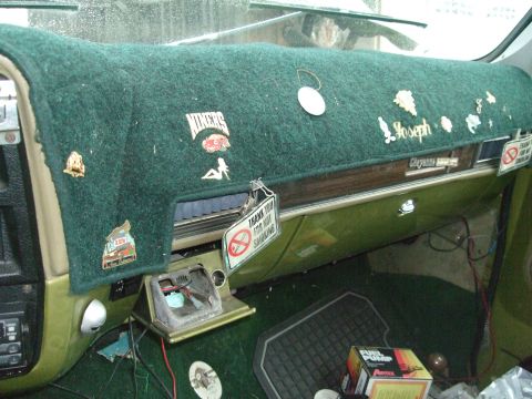 1979 Ford Bronco - The interior dashboard of a vehicle, adorned with various patches and a no-smoking sign.