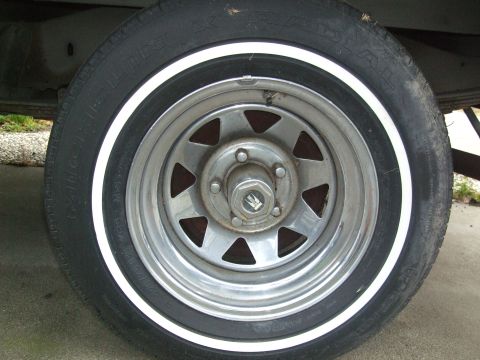1979 Ford Bronco - This image shows a close-up of a wheel with a whitewall tire, a distinctive triangular spoke pattern.
