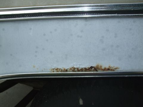 1979 Ford Bronco - Close-up view of rust forming along the bottom edge of a vehicle's body panel.