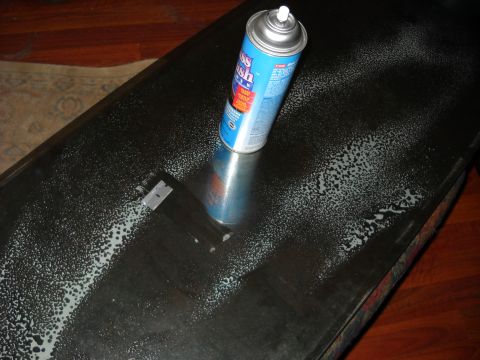 1993 Ford C-150 (Centurion Conversions) - A spray can of glass cleaner and a razor blade are on a dark surface with a speckled pattern.