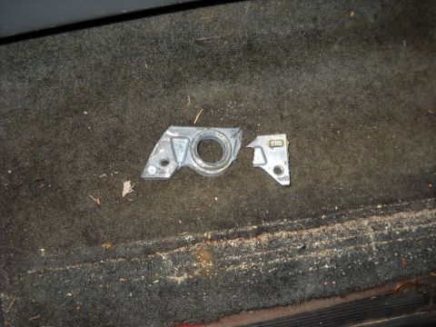 1993 Ford C-150 (Centurion Conversions) - A close-up view of a damaged metal bracket lying on the floor of a vehicle.